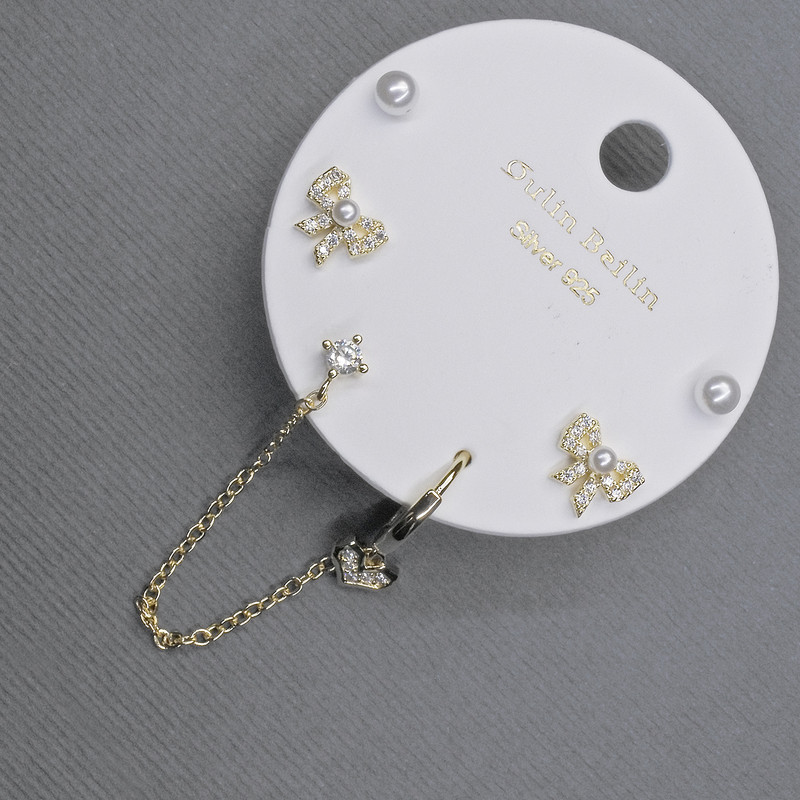 Boucles d'oreilles à clous dorées avec capuchon décoratif et strass blancs